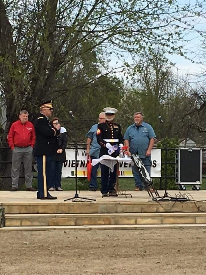 A group of people stand on an outdoor stage